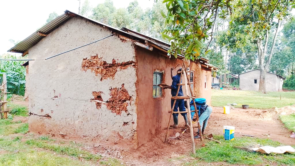 New earthen home under construction with timber frame and iron roof